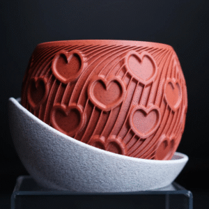 HEART – esencja uczuć w formie designu Doniczka HEART to manifest emocji zamknięty w geometrycznej perfekcji. Stworzona z myślą o wyjątkowych chwilach, stanowi niebanalny prezent dla ukochanej osoby – pełen symboliki, a zarazem absolutnie współczesny. Na powierzchni eleganckiego korpusu w odcieniu klasycznej czerwieni wyrzeźbiono rytmiczne serca, harmonijnie wtopione w dynamiczne linie przypominające strumień energii lub zakodowane wyznanie. To coś więcej niż doniczka – to designerski artefakt, który celebruje uczucie w jego najczystszej formie. Osadzona w kontrastującej, teksturalnej podstawce, HEART zyskuje charakter obiektu galeryjnego, a nie tylko użytkowego. Doskonała na Walentynki, rocznicę, dzień zaręczyn lub jako intymny gest bez okazji. Dostępna w wymiarach: 130 × 130 × 100 mm (szerokość × głębokość × wysokość) Podaruj coś, co nie zwiędnie. HEART – design, który mówi „kocham” bez słów.